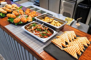 A buffet with various food items including sandwiches, salads, and potato wedges. - Tarata Hotel Boutique (Lima)