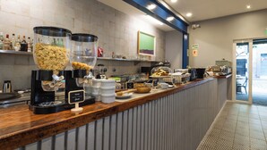 A breakfast bar with cereal dispensers, a coffee machine, and various breakfast items. - Tarata Hotel Boutique (Lima)