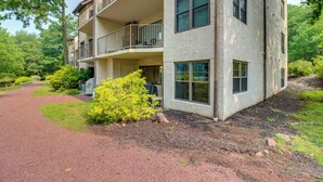 A multi-story building with balconies, a gravel path, and surrounding greenery.