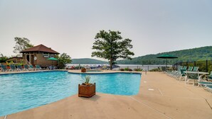 A swimming pool with lounge chairs and a wooden deck area.