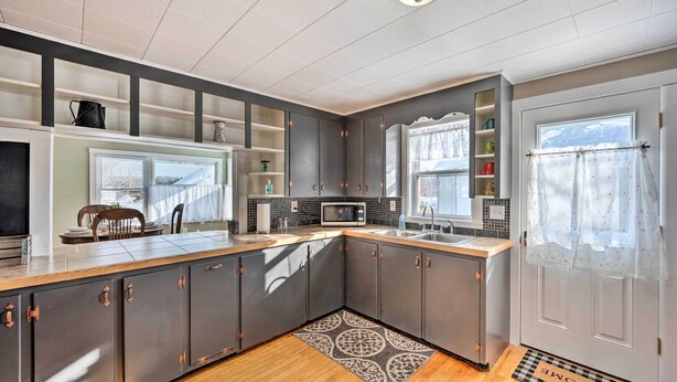 A modern kitchen with grey cabinets, a wooden countertop, and a patterned rug. - Andover House w/ Private Yard & ATV Trail Access! (Andover)
