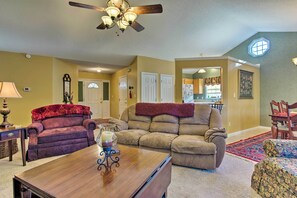 A living room with a sofa, armchair, and coffee table. There is a ceiling fan, a lamp, and a rug. - Asheville Area Home W/patio-11 Mi to Biltmore (Fletcher)