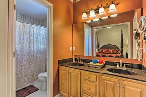 A bathroom with a double sink, wooden cabinets, a large mirror, and a shower curtain. - Asheville Area Home W/patio-11 Mi to Biltmore (Fletcher)