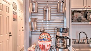 Eine Küche mit Kaffeemaschine, Popcornmaschine und Küchenutensilien, die an der Wand hängen.