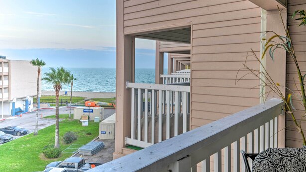 Ein Balkon mit Blick auf Strand und Meer.