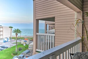 A balcony with a view of the beach and ocean.