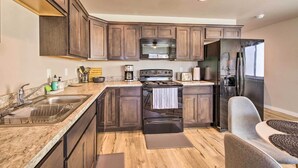 A modern kitchen with dark wood cabinets, a stainless steel refrigerator, a built-in microwave, and a gas stove. - Belgrade Vacation Rental w/ Mountain Views! (Belgrade)