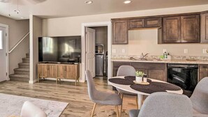A modern kitchen with dark wooden cabinets, a built-in oven, and a dining area with a round table and grey chairs. - Belgrade Vacation Rental w/ Mountain Views! (Belgrade)