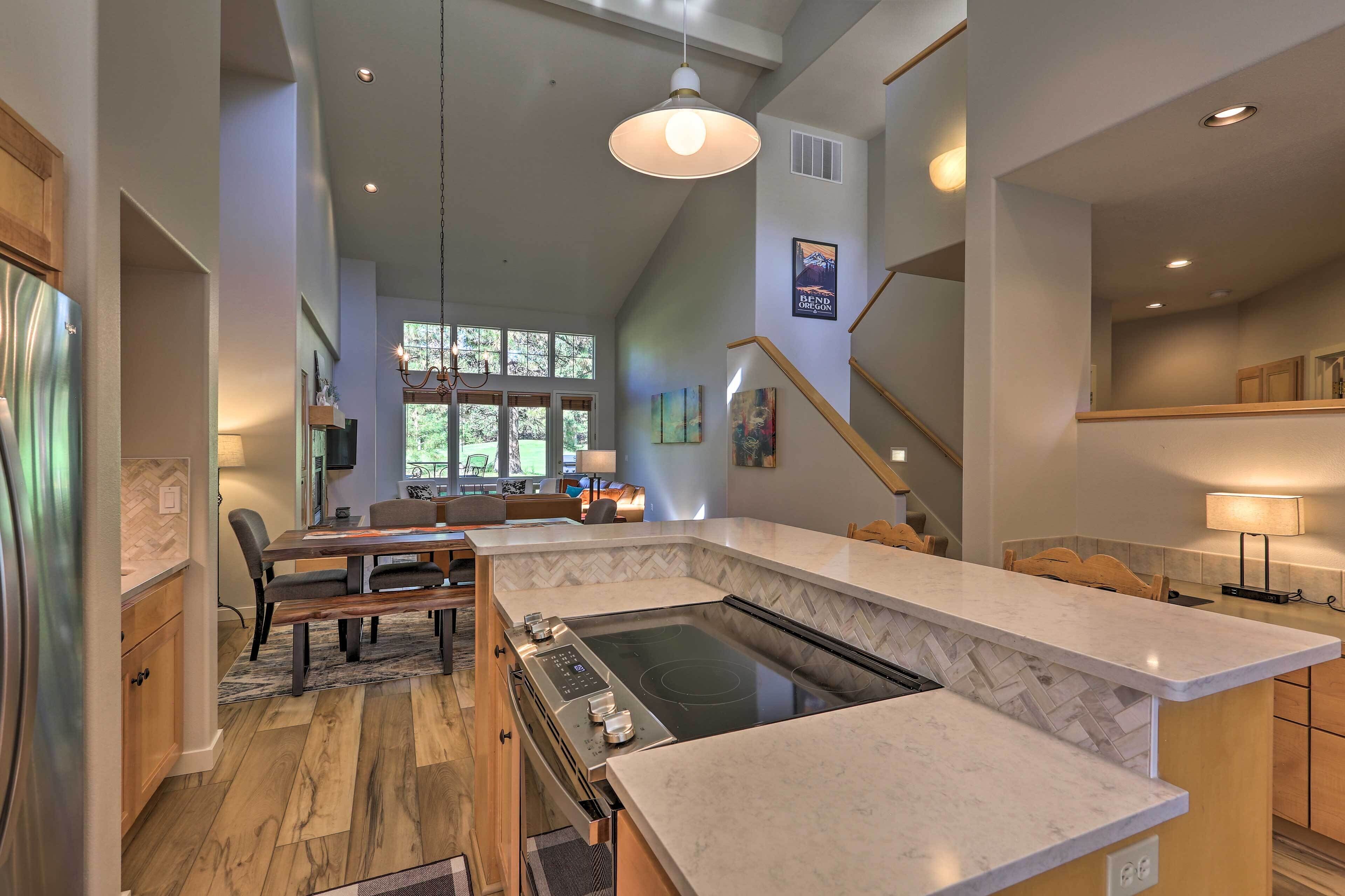 A modern kitchen with a built-in stove, wooden flooring, and a large island.