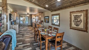 A dining area with a wooden table set for four, flanked by wooden chairs. - Charming Texas Home w/ Stunning Canyon Views! (Canyon)