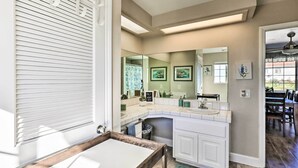 A modern kitchen with white cabinets, a large island, and a view of the dining area. - Garden, Gazebo & Fire Pit: Fallbrook Home! (Fallbrook)
