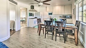 A spacious kitchen with wooden flooring, a dining table with chairs, and a ceiling fan. - Garden, Gazebo & Fire Pit: Fallbrook Home! (Fallbrook)
