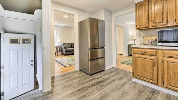 A kitchen with wooden cabinets, a stainless steel refrigerator, and a countertop with a microwave. - Charming Hamden Home: 2 Mi to Yale University (Hamden)
