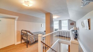 Un dormitorio con cama, ventana y escalera.