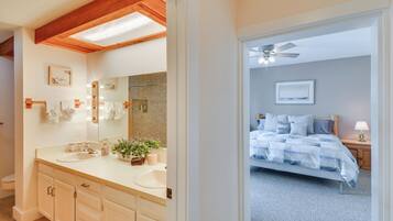 Ein Schlafzimmer mit Bett, Nachttisch und Deckenventilator.