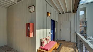 A covered porch with a wooden bench, a red cabinet, and a blue door.