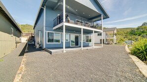 A two-story building with a balcony on the upper floor, a covered front porch, and a gravel driveway. - Clearlake Vacation Rental w/ Nearby Lake Access! (Clearlake)