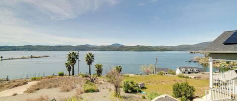A coastal property with a view of the sea, a sandy area with sparse vegetation, and a house with a solar panel.