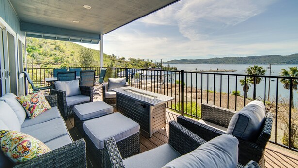 A covered outdoor seating area with wicker furniture and a view of a lake. - Clearlake Vacation Rental w/ Nearby Lake Access! (Clearlake)