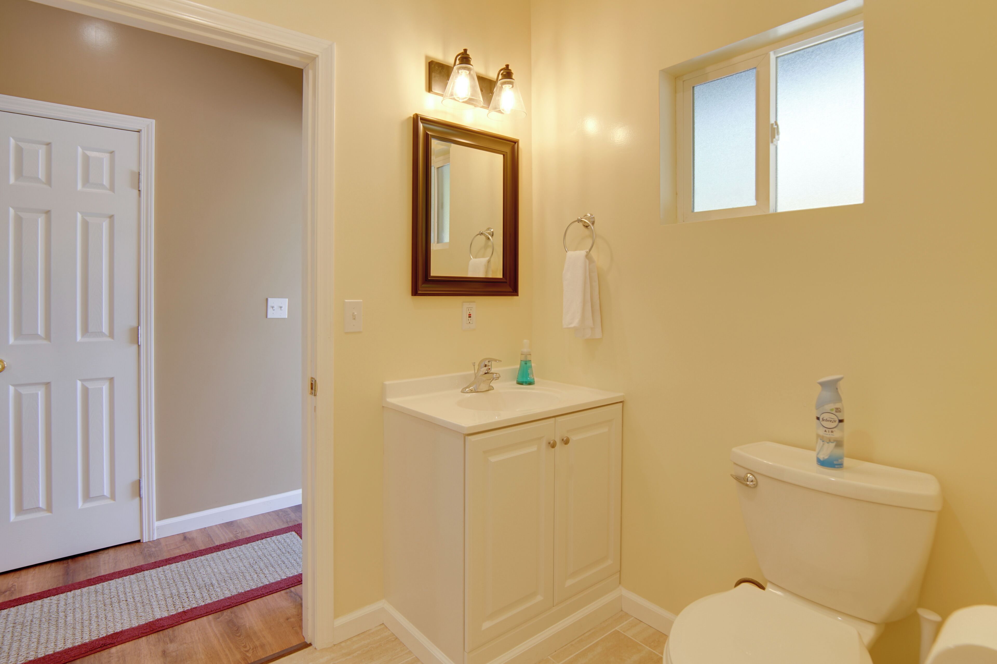 Une salle de bain avec des toilettes, un lavabo et un miroir.