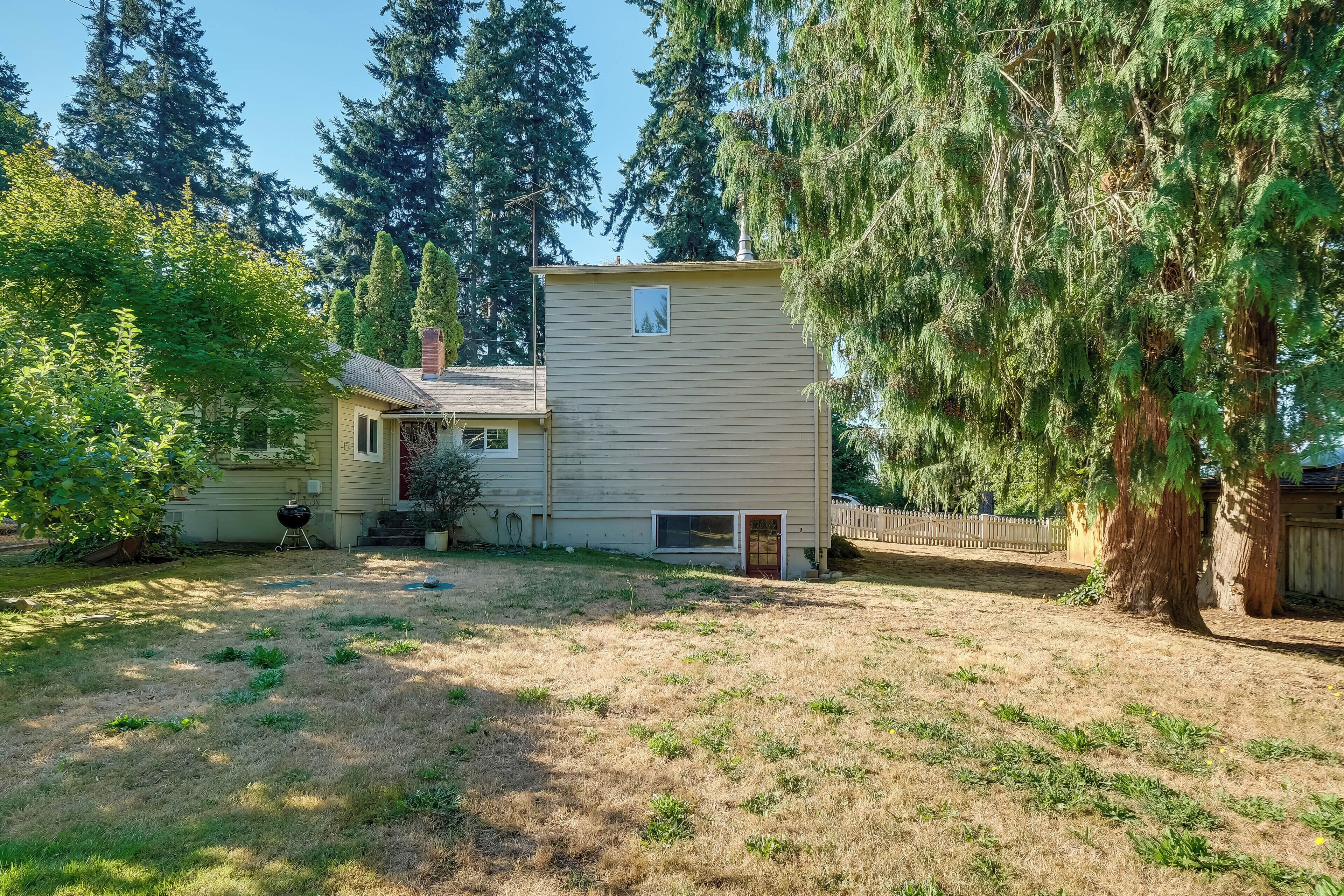A house with a yard, a chimney, and a window.