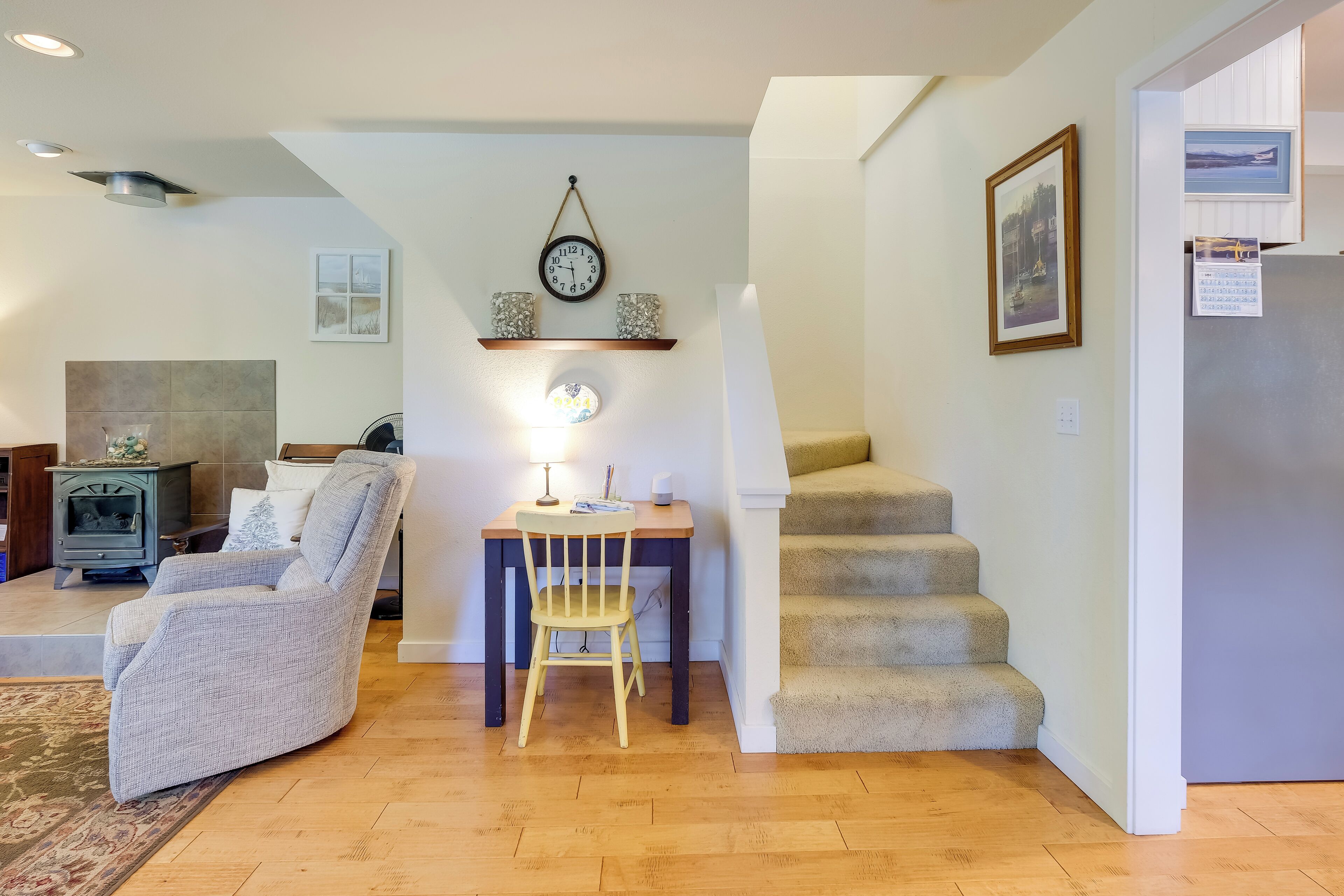 A living room with a fireplace, a dining area with a table and chairs, and a staircase leading to another level.