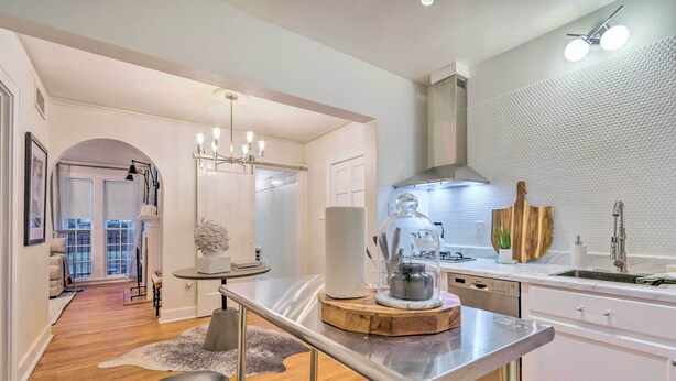 A modern kitchen with a central island, stainless steel appliances, and a view to the dining area.