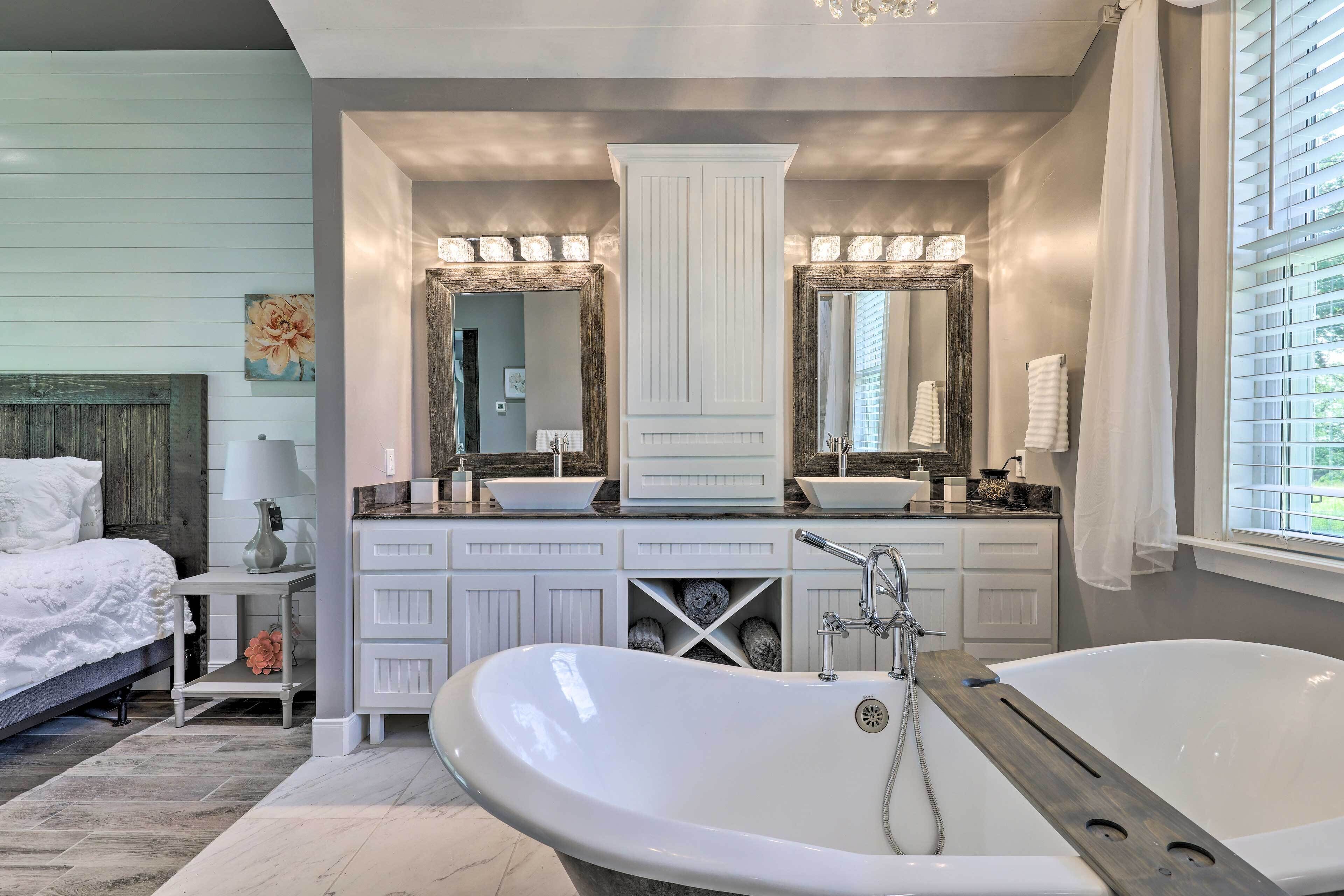 A modern bathroom with a freestanding bathtub, double sinks, and a large mirror above the vanity.