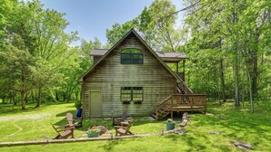 A rustic wooden cabin with a porch and a small deck, surrounded by lush greenery and trees. - 5 Mi to Dtwn: Serene Couple's Retreat in Franklin! (Franklin)