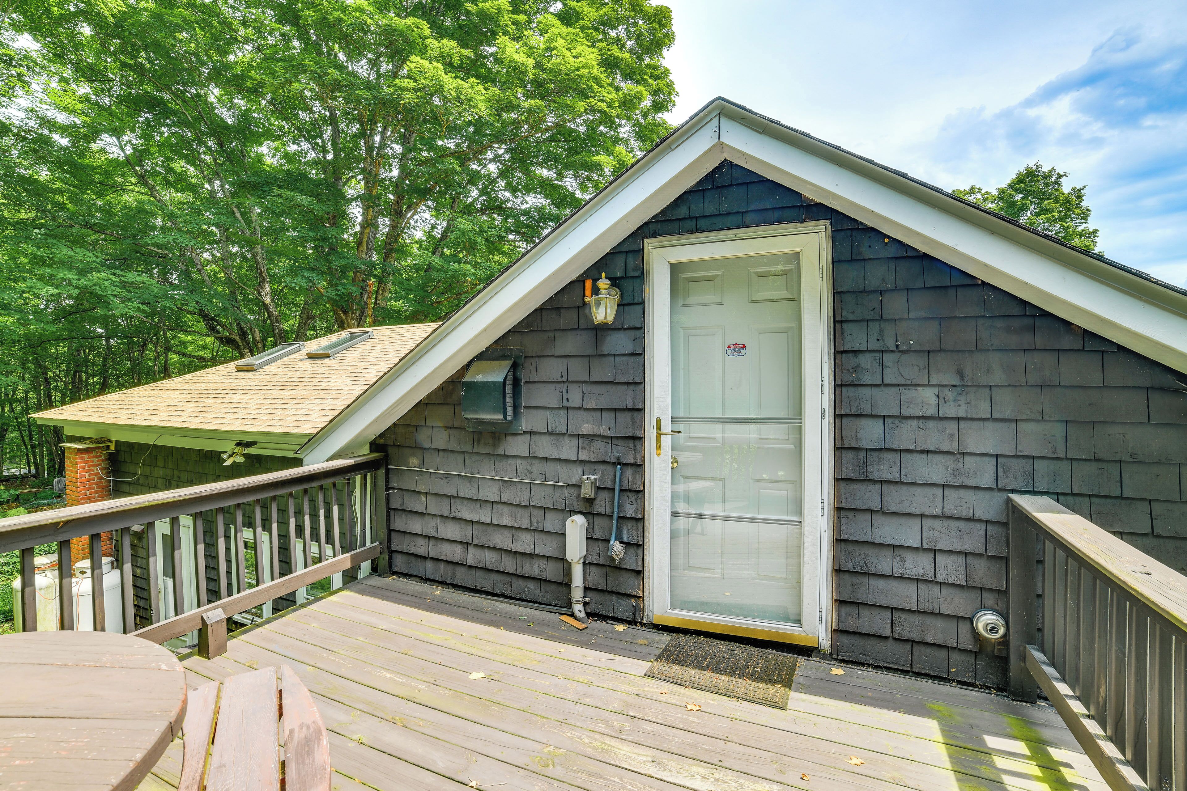 A wooden deck with a railing, a door, and a small window.