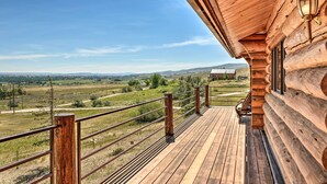 Eine Holzterrasse mit Metallgeländer mit Blick auf eine ländliche Gegend.