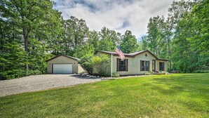 A two-story house with a garage, surrounded by a well-maintained lawn and trees. - Cozy Hale Home Between Long & Loon Lakes! (Hale)