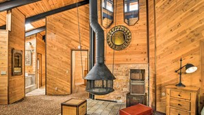 Ein Holzinnenraum mit Kamin, einer runden Wanddekoration und einer roten Truhe.