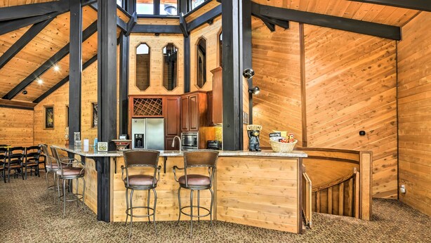 Ein rustikales Holzinterieur mit Barbereich, hohen Decken und einem einladenden Schild.