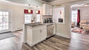 A modern kitchen with white cabinets, stainless steel appliances, and a large window. - Dog-friendly Downtown Auburn Vacation Rental! (Auburn)