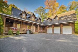 A log cabin with a porch, two garage doors, and a driveway. - Dog-friendly Gaylord Retreat < 8 Mi to Town! (Gaylord)