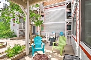 A covered patio with two Adirondack chairs, a grill, and a small garden area. - Walk to Slopes: Dtwn Breckenridge Condo on Main St (Breckenridge)