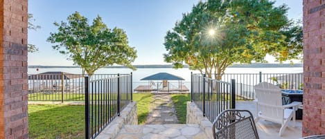 Un espace patio avec vue sur l’eau, un paillasson et des sièges d’extérieur.