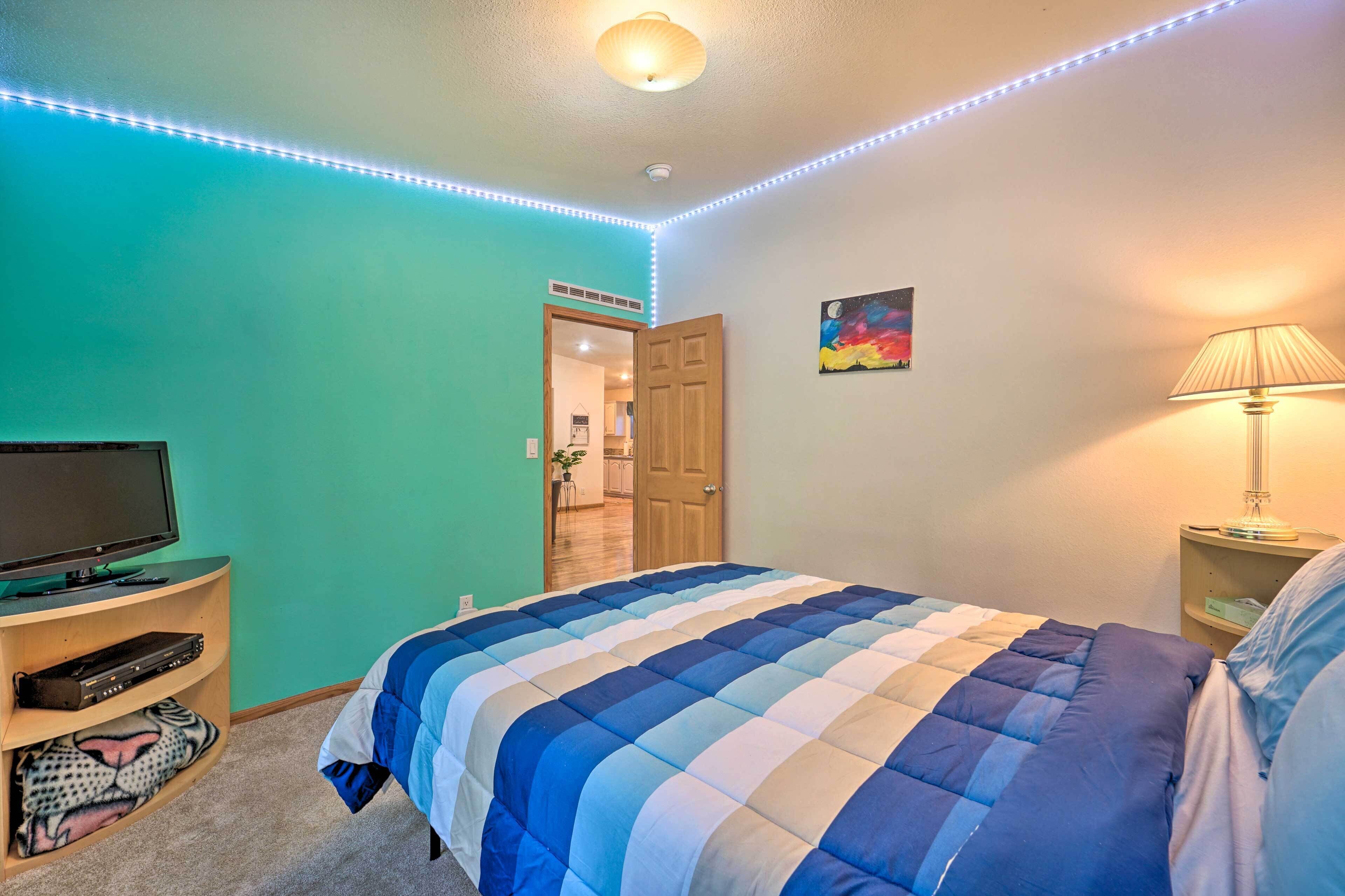 Een slaapkamer met een bed, een televisie en een lamp.
