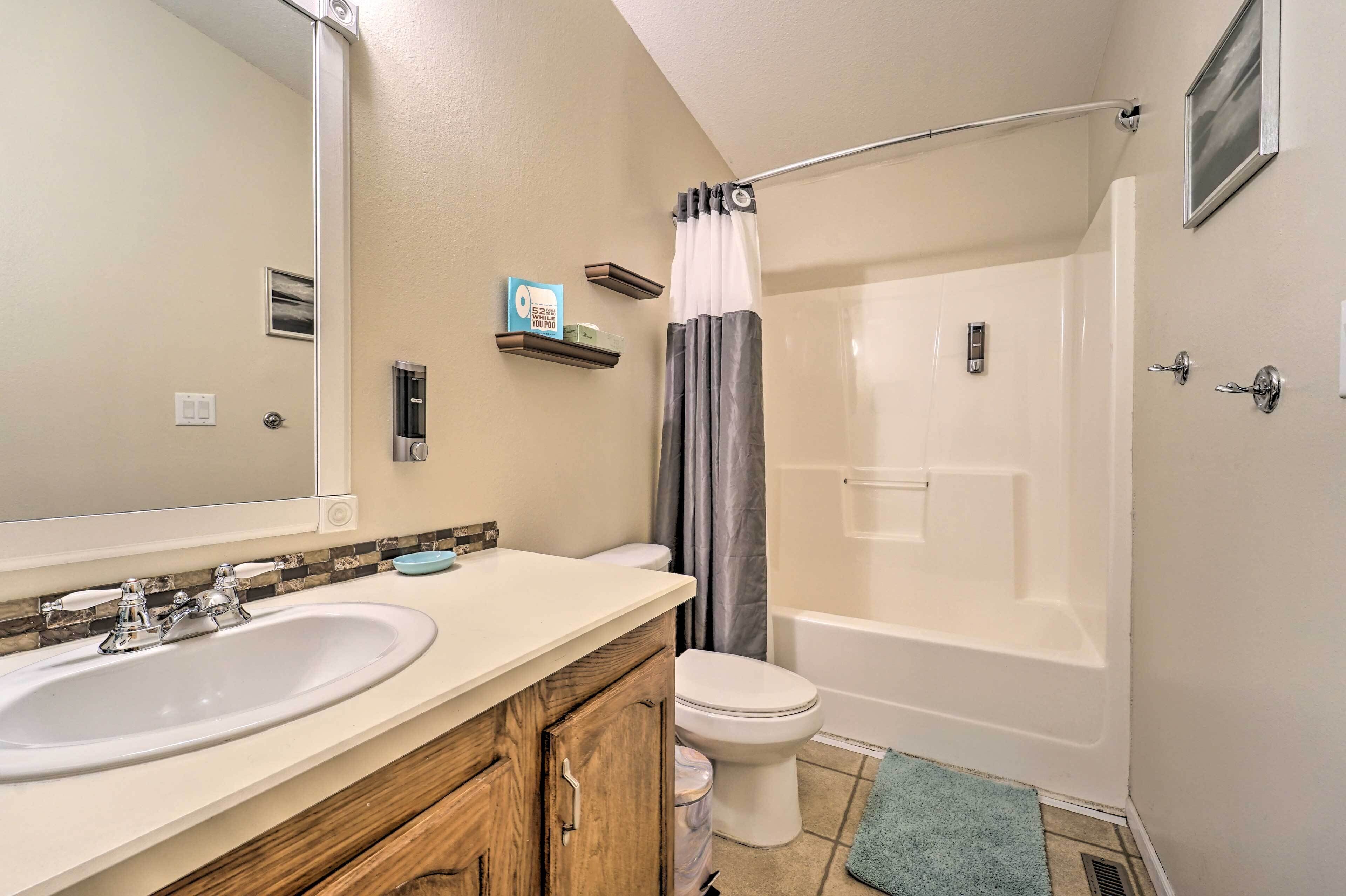 A bathroom with a double sink, toilet, and bathtub.