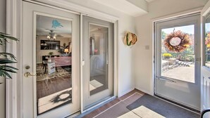 A modern entryway with a sliding glass door leading to a dining area, a decorative wreath on the wall, and a view of the outdoors. - Lovely Moshannon Ground Apartment w/ Fire Pit (Moshannon)