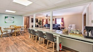 A spacious kitchen with a central island, wooden chairs, a dining table, and a coffee machine. - Lovely Moshannon Ground Apartment w/ Fire Pit (Moshannon)