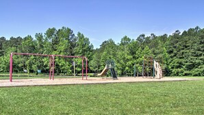Un parque infantil con columpios, toboganes y estructuras para escalar en un área verde.