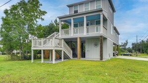 Ein zweistöckiges Haus mit Balkon, Treppe und Garage.