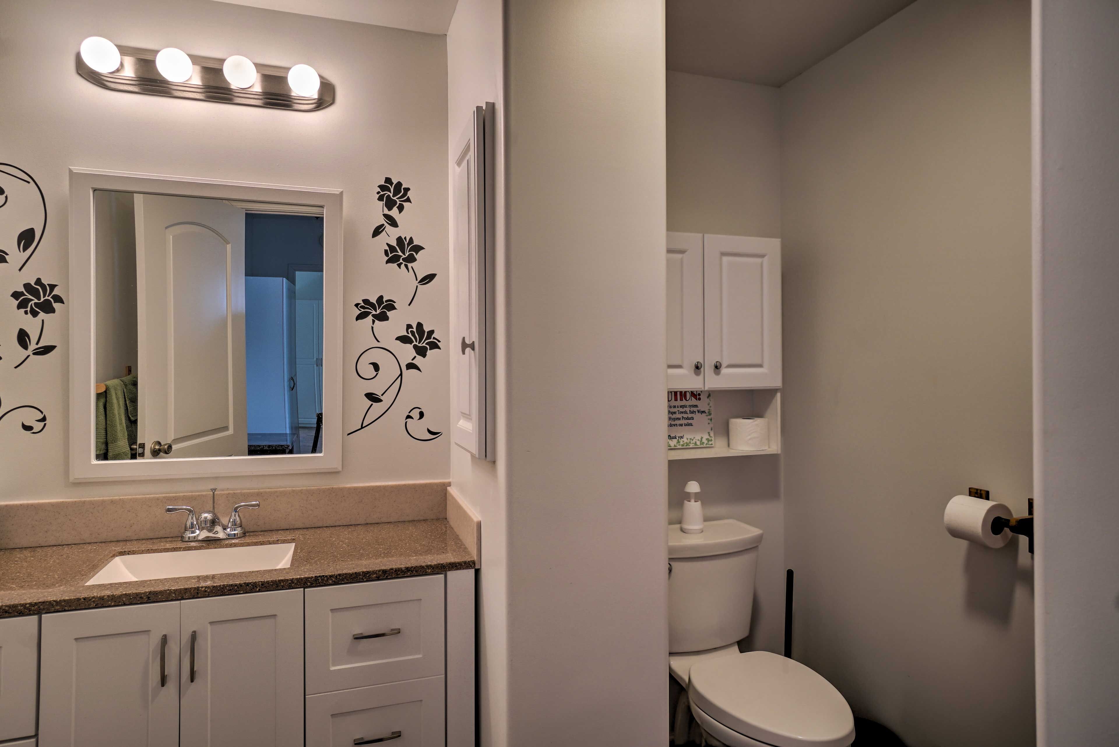 A bathroom with a sink, mirror, and toilet.