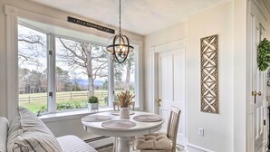 A dining area with a round table, a chandelier, and a view of the outdoors. - Lush, Modern Farmhouse w/ Mtn Views & Sunroom (Edinburg)
