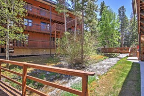 A wooden building with balconies overlooking a stream, surrounded by trees. - Pool & Hot Tub Access: Mountainside Breck Condo (Breckenridge)