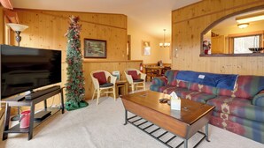 A cozy living room with a flat-screen TV, a Christmas tree, a sofa, and a coffee table. - Mountain-view Angel Fire Escape 'ace's Place' (Angel Fire)