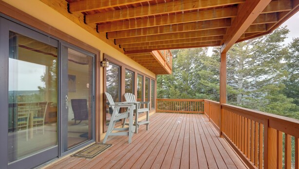A wooden deck with a railing, a glass door, and a chair. - Mountain-view Angel Fire Escape 'ace's Place' (Angel Fire)