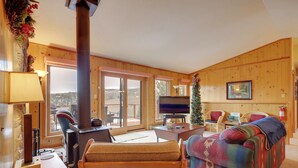 A cozy cabin interior with a fireplace, a television, and a Christmas tree. - Mountain-view Angel Fire Escape 'ace's Place' (Angel Fire)